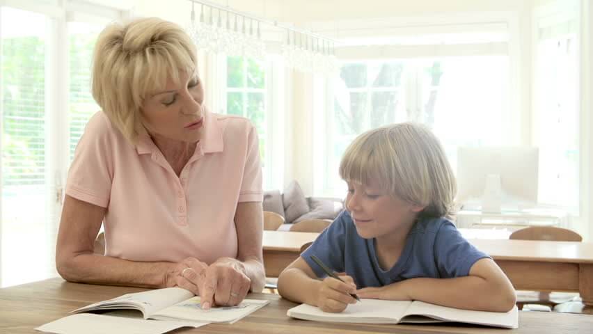 Senior woman providing after school child care, helping with homework